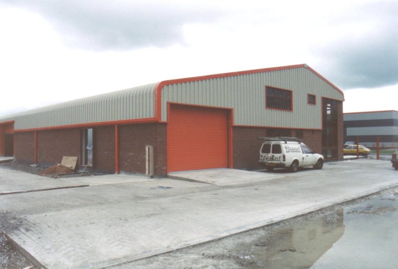 Curved_Eave_and_Red_Sheeting_Steel_Building_Industrial_Factory_Custom_Precision_UK_01